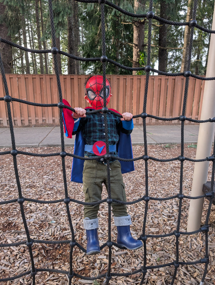 Boy in playground wearing Creative Capes costume with a spiderman facemask. Image entered in our photo contest for super hero kids
