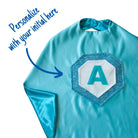Personalized Kids superhero cape costume made with quality satin in aqua. Each cape emblem features the child's first initial