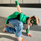 boy in positive affirmation green and black personalized superhero costume set,  dress-up costume kit - lined satin cape, shield, mask, belt, and wrist cuffs. Handmade by Creative Capes in USA to inspire imaginative play and confidence, activity for healthy childhood.