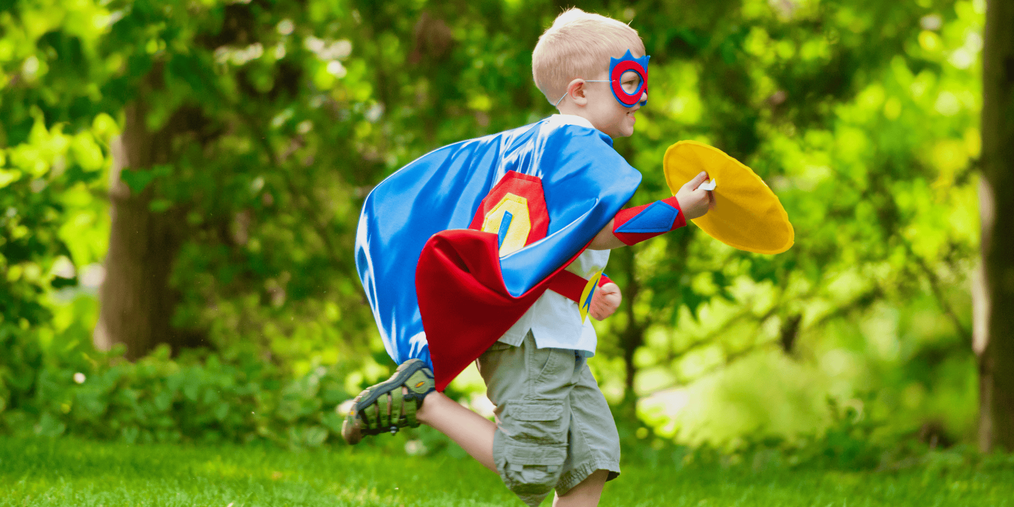 5 year old boy in Creative Capes superhero costume playing outdoors with quality cape set made for active play.