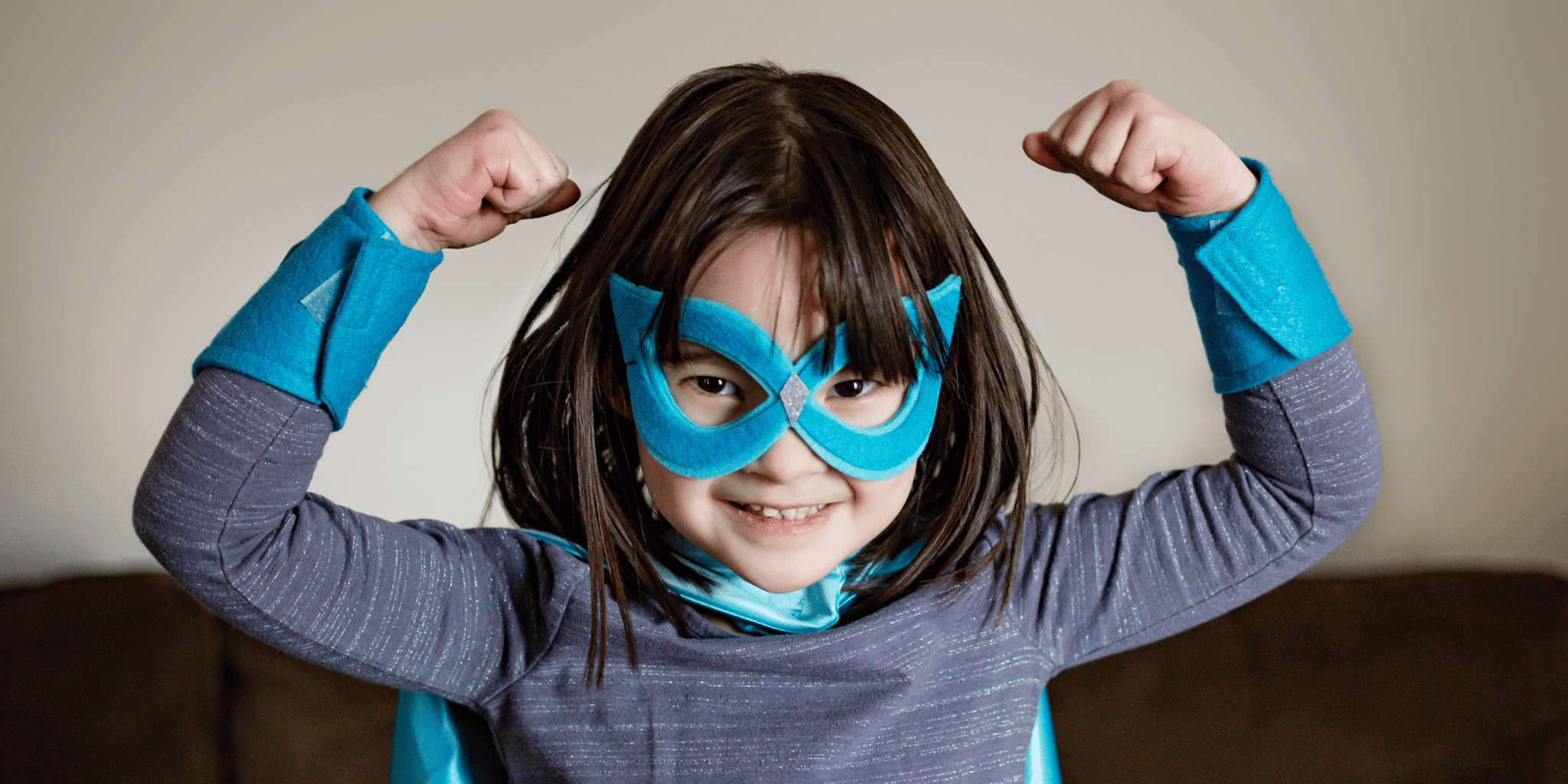 5 year old girl wearing a superhero costume with blue mask, cape and super hero accessories, flexing muscles. Made in the USA by a small shop - Creative Capes