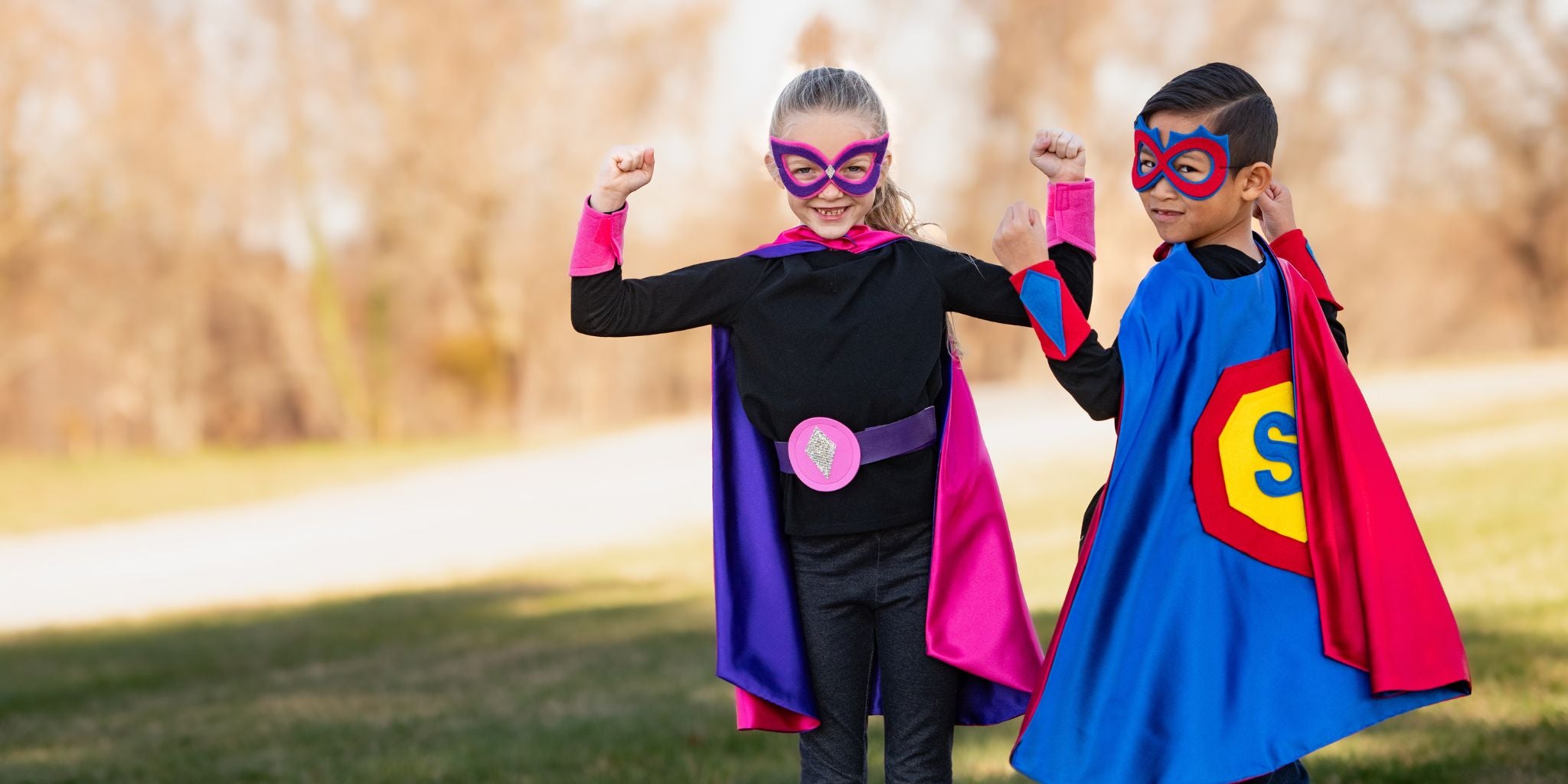 7 year old girl in pink cape and boy in a blue cape, superhero costume customized with child's initial to become their own super hero, Creative Capes encouraging healthy screen-free play activities