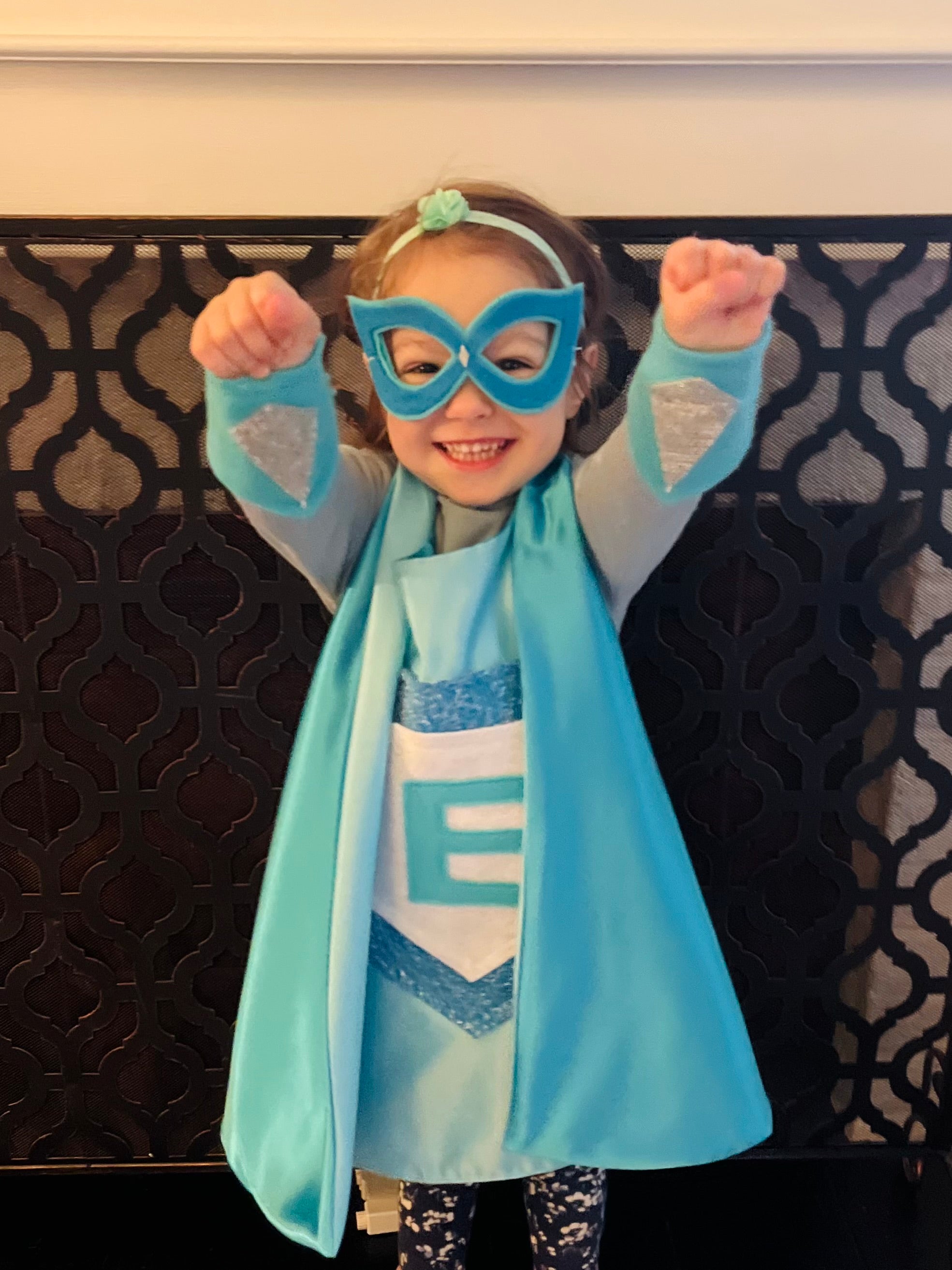 Child smiling in superhero costume with blue cape and mask, quality costume handmade in the USA by Creative Capes