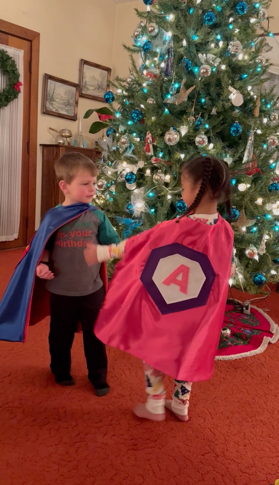 boy and girl in Christmas gift of personalized capes from Creative Capes
