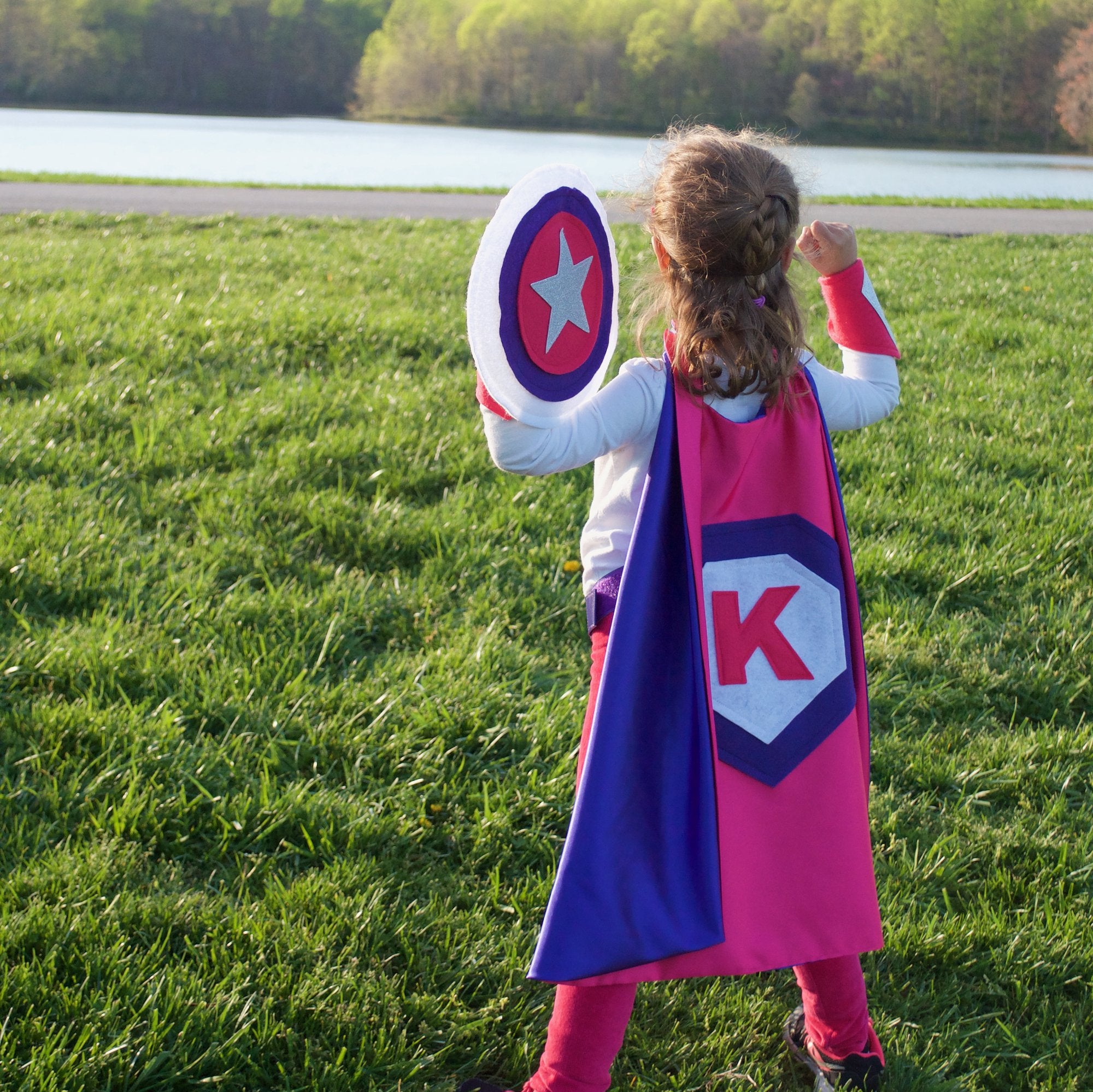 girl empowered in purple and pink personalized superhero costume set, superhero cape featuring the child's first initial, dress-up costume - lined cape, shield, mask, belt, and wrist cuffs, handmade by Creative Capes in USA to inspire imaginative play and confidence, Play activity for healthy childhood, no screen time