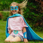 girl in frozen inspired costume. Satin lined cape, eye mask, and wrist cuffs.
