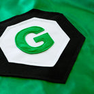 closeup of personalized green and black cape emblem, quality and durability, Creative Capes personalized satin superhero capes for kids
