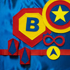 personalized blue, red and yellow superhero costume set, featuring the child's first initial on the super hero cape, quality dress-up costume kit includes a lined satin cape, shield, mask, belt, and wrist cuffs, handmade by Creative Capes in USA to inspire imaginative play and confidence. Play without screens creates a healthy childhood.