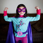girl in purple and pink personalized superhero costume set, creative play activity, ages 3 to 8 years old, quality dress-up costume kit - satin cape, shield, mask, belt, and wrist cuffs, handmade by Creative Capes in USA, toy to inspire imaginative play and confidence, activity for imaginations, no screens for a healthy childhood