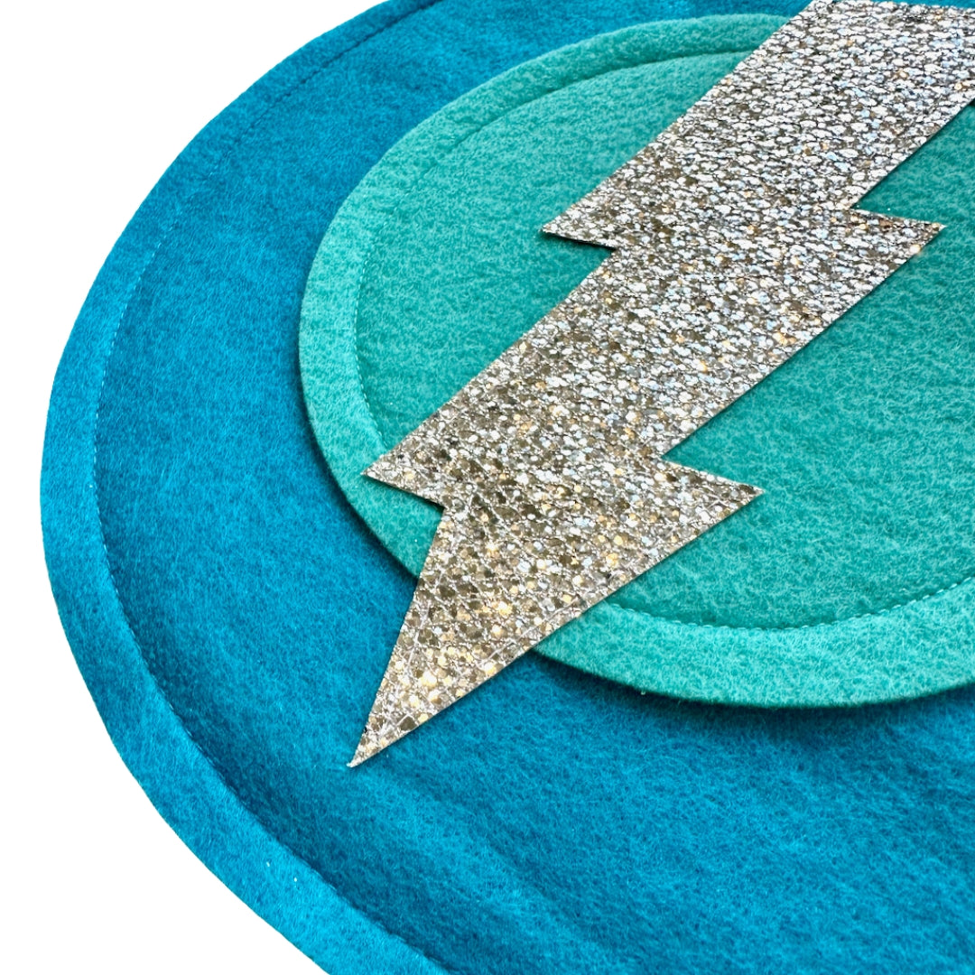 Close up of Felt dark aqua shield with silver bolt