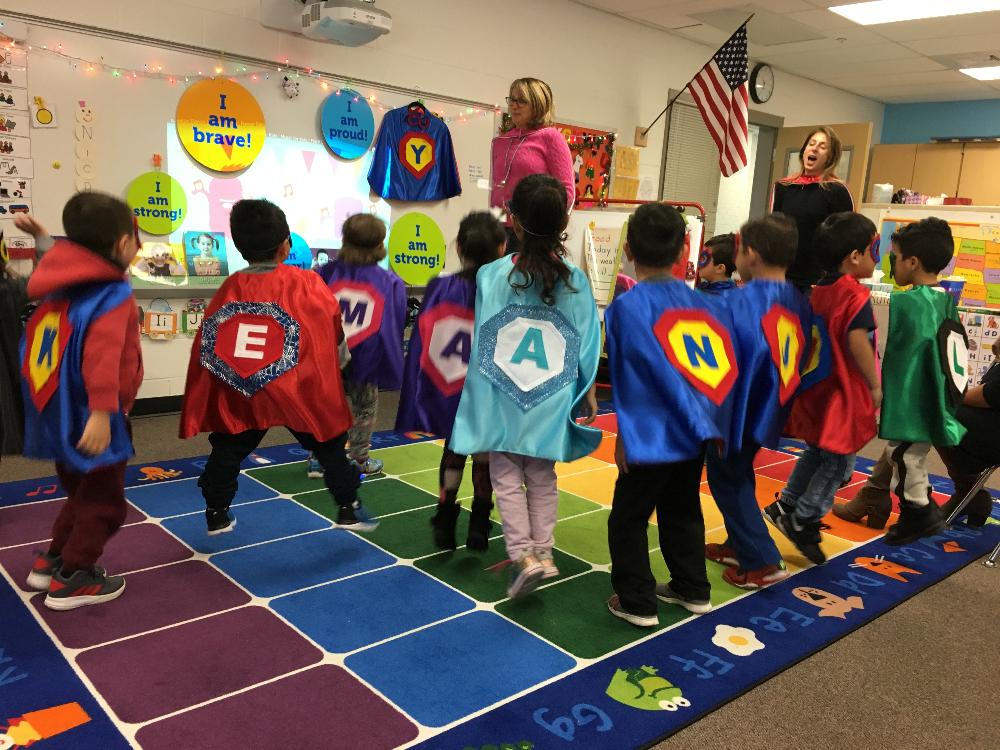 preschoolers and teachers jumping in their super hero costumes by Creative Capes