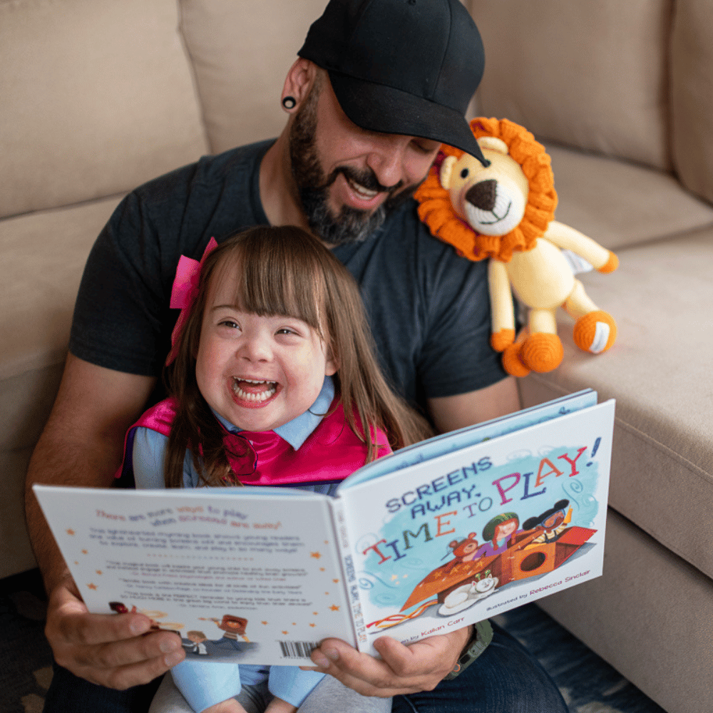 Dad and daughter reading a book together called Screens Away, Time to Play! by Kailan Carr, available for sale at CreativeCapes.com 
