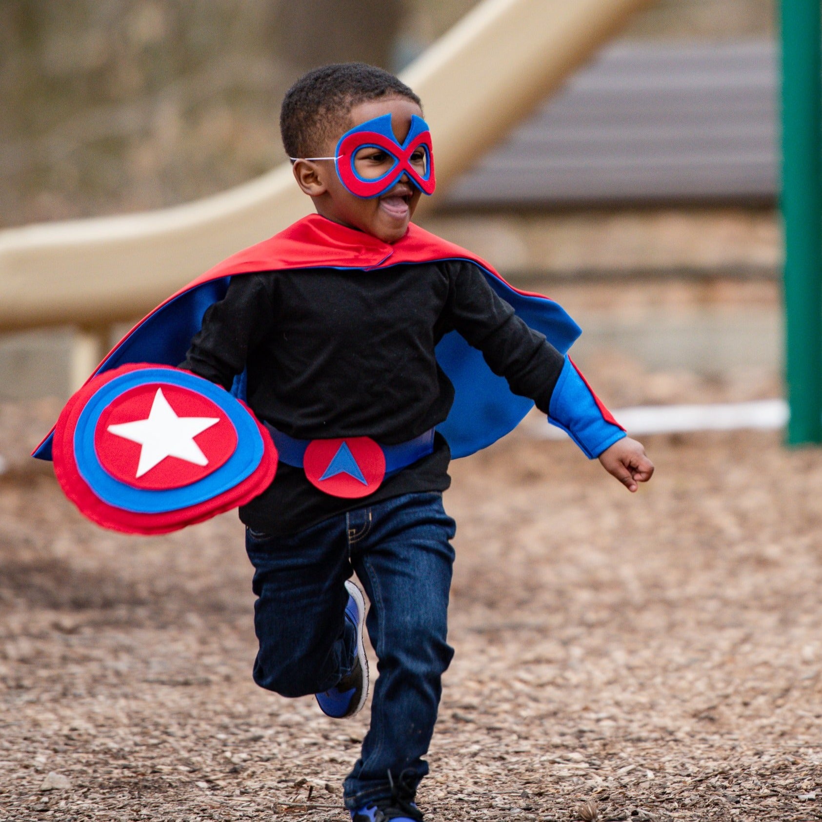 boy playing outside, handmade superhero costume in red and blue, Creative Capes outfit includes mask, belt, satin cape and shield, Best childhood toy to encourage creative playtime that is durable