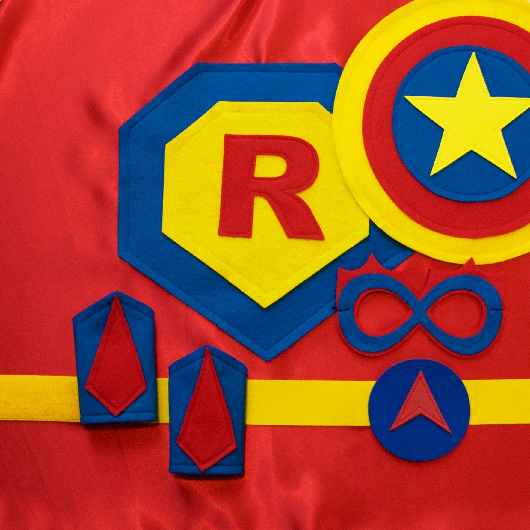 Red, blue and yellow personalized superhero costume set for kids, child's first initial on the super hero cape, dress-up costume kit - a lined satin cape, shield, mask, belt, and wrist cuffs, handmade by Creative Capes in USA, toy to inspire imaginative play and confidence